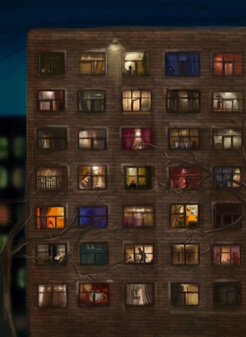 a brick apartment building at night, its windows lit in different colors with people visible inside, bare tree branches across the wall